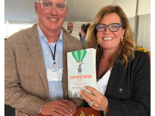 Denise Grothouse and Greg Rohl with a copy of his book The Corpratenuer Plan