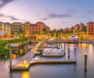 Boats, high-rise buildings in Naples, FL at sunset.