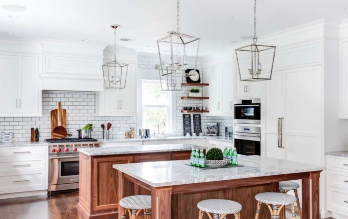 A kitchen with 2 islands and white kitchen cabinets. Represents ad trends.